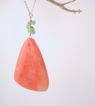 Large orange stone with green glass beads